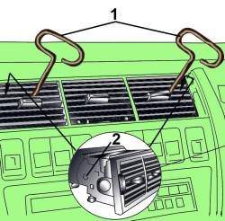 Использование приспособления (1), установленного в отверстия (2), для снятия вентиляционной решетки из центральной секции панели приборов